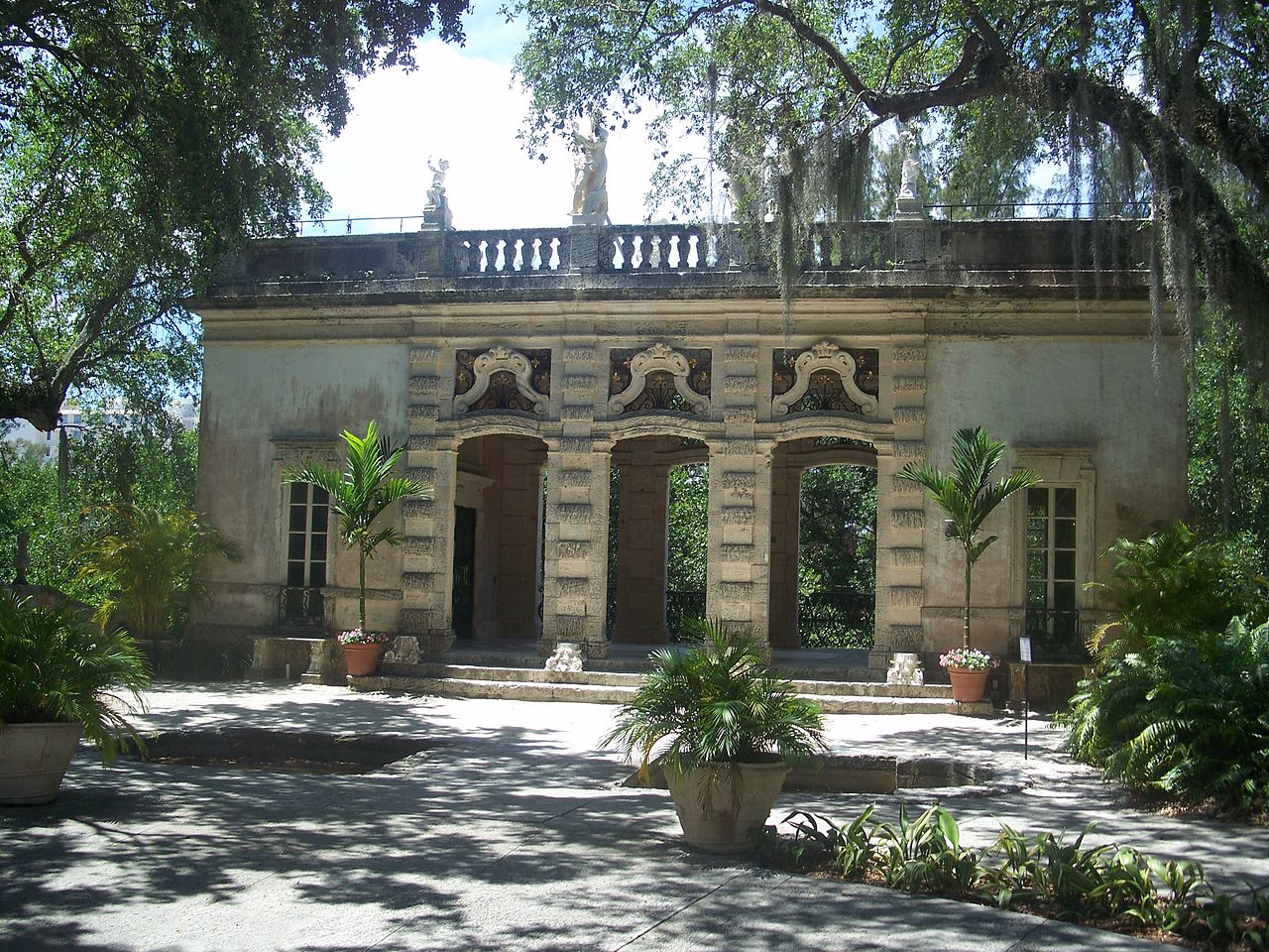 A stylishly set dinner table on a patio in Coconut Grove with tropical plants and modern glassware